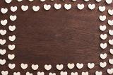 White heart border or frame on a wooden background with central copy space symbolic of love and romance