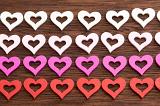gradient coloiured rows of hearts on a wooden surface