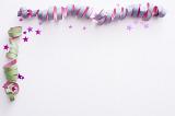 Party streamer corner border decoration with spiral twirled streamers and scattered stars on white with copy space