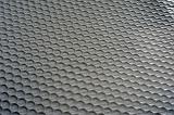 Extreme close up view of black plastic mat with rows of circles pressed into it