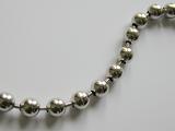 Top down view on close up of chrome finished balls attached to one another in metal necklace