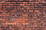 Old weathered brick wall background texture with discolored red bricks in parallel rows showing architectural detail