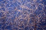 Tangled metal wires over blue background for concept about electronics or recycling for industry