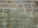 Stone and mortar wall with pale green moss or algae stains near bottom half with copy space