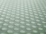 Extreme close up of bubbled surface in long rows and colored in light sea green