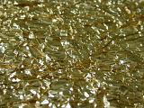 Extreme close up of shiny crumpled gold leaf creating an abstract background