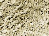 Detailed background of wrinkled foil in yellow hue with rough texture with copy space