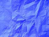 Layers of simple wrinkled blue wrapping paper as abstract background with copy space