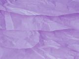 Background texture of soft crinkled or crumpled soft tissue paper in a lilac color, full frame