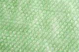 Extreme close up of bubble wrap with slanted rows on green background