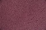 Close up on maroon colored little loopy fabric string in rows as abstract background with copy space