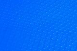 Top down selective focus view on blue rubber sheet with bumps for traction close up