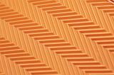 Abstract background composed of a close up view orange tread marks arranged in slanted patterns