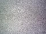 Top down close up view of worn out white carpet fabric in random rows as abstract textured background
