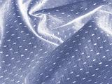 Abstract background composed of blue wrinkled fabric with silver dashes in it