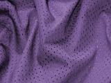 Soft luxurious folded purple fabric with a sateen pattern of darker dots in a full frame decor background