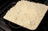 Preparing a shepherds pie recipe with savory mince or sausages topped with a mashed potato crust waiting in an oven dish to be baked or grilled