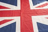 Textile British Union Jack Flag laid out at an oblique angle showing texture and crease detail, full frame background