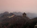 Atmospheric scenic landscape in colorful mist of the Great Wall of China and its lookout towers stretching away across mountain peaks in a travel concept