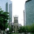 a church nestled between two huge dominating office blocks, montreal, canada