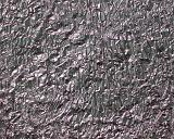 Close up full frame view of crinkled, textured metallic silver paper or material