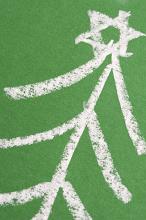 Hand-drawn Christmas tree topped with star sketch at a diagonal on a green chalkboard, close up view