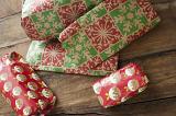 Pile of brightly colored Christmas gifts in festive wrapping on a wooden floor viewed high angle