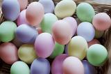 A basket filled with colourful boiled and dyed hens eggs for Easter in pastel shades.
