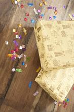 a wooden surface with birthday decoration sprinkles and two wrapped presents