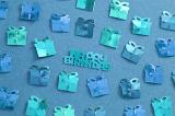 Blue Metallic Happy Birthday Confetti Scattered on Blue Background, Shaped like Wrapped Presents with Birthday Message in Middle