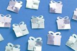 Close Up of Gift Present Shaped Foil Cut Out Confetti on Blue Background