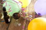 Over View of Birthday Balloons, Streamers and Confetti with Bottle and Glass of Red Wine Still Life
