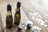 Two Mini Bottles of Champagne Beside Champange Flute Glasses Surrounded by Confetti on Wooden Background, Celebration Themed Image for New Years or Christmas