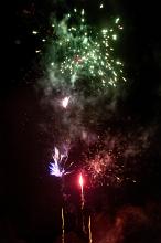 Colourful pyrotechnics display to celebrate a special occasion withpink, green and red fireworks exploding in the night sky