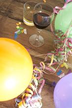 Over View of Glasses of Alcohol Surrounded by Balloons, Streamers and Confetti in Birthday Celebration Themed Image