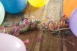 Close up Party Streamers, Balloons and Confetti on Top of Wooden Table, Emphasizing Festivity.