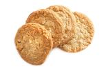 Four golden crunchy oat biscuits arranged in a fan isolated on a white background