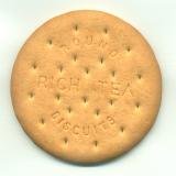 Close up view of a single Round Rich Tea Biscuit showing the texture and text on a white background