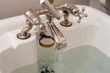 olf fashioned bath taps with water running into the bath