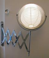 a light reflected in a metal bathroom shaving mirror