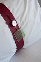 White pillow in an upmarket hotel bedroom with a decorative band tagged - Soft - on an attached label, close up view