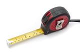 Builders retractable tape measure with scales in both inches and centimeters on white ina DIY and renovation concept