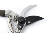 Open pair of garden pruning shears or secateurs with a close up of the blades and recoil spring on a white background