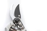 Pair of secateurs or pruning shears for pruning plants in the garden showing the ratchet mechanism and sharp blades in the open position on white with copyspace