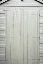 Close white painted double wooden shed doors in a close up full frame architectural view