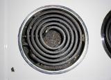 Overhead view of a spiral oven electric hot plate heating element on a white stove top