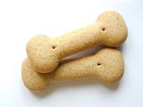 Closeup of two bone shaped dog biscuits providing a healthy nutrition for your pet on a white background