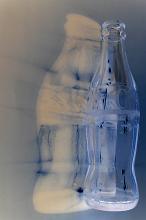 Closeup of a single empty clean transparent glass Coca Cola drinks bottle with reflection - not model released