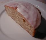 High angle closeup of a halved freshly baked cake with icing served on a white plate as a delicious dessert or snack