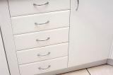 White kitchen cabinet with a row of closed drawers and a cupboard door